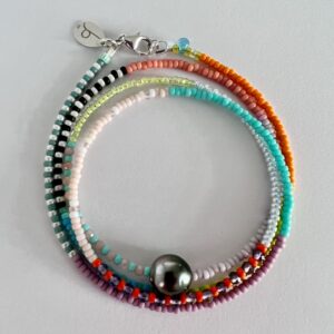 Handgemachtes Beads Armband Tahiti Perle für Damen und silbernen Akzenten vor hellem Hintergrund.