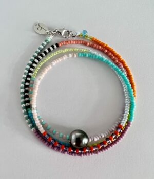 Handgemachtes Beads Armband Tahiti Perle für Damen und silbernen Akzenten vor hellem Hintergrund.